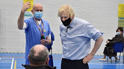 Boris Johnson speaks to a man waiting for a Covid-19 vaccine at a centre in Fermanagh