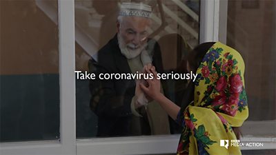 An actor playing a grandfather in Afghanistan touches his granddaughters hand against a pane of glass in a window - to demonstrate how to stay safe from COVID-19.