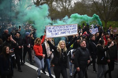 Anti-lockdown protesters march in London carrying placards