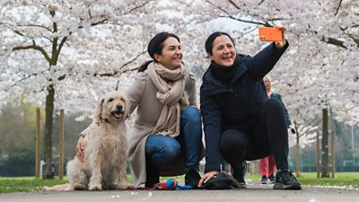 File photo: People pose for a selfie with a dog in Battersea Park