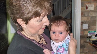 Jude Stewart holding a baby