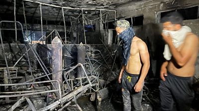 People look at damage caused by fire