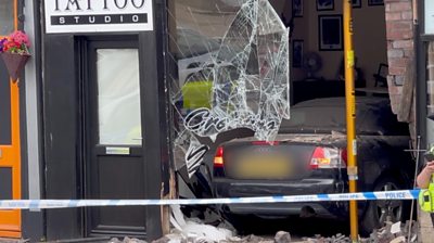 A car wedged in a building window