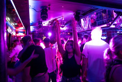 A woman dances on the first night clubs reopen in England