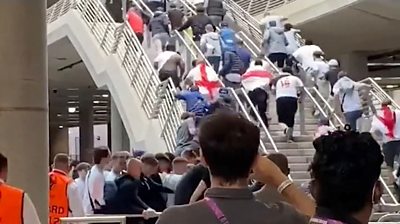 Football fans run up stairs