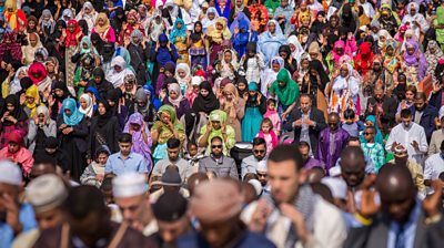 Hundreds of people from Muslim communities in walking. Some wearing traditional dress and a mix of people from different background.