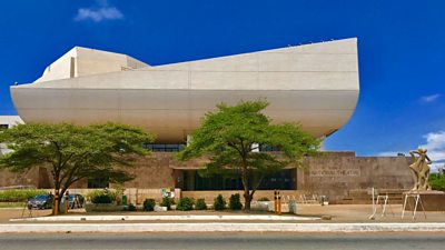 The National Theatre, Accra Ghana in Africa. Two trees in front of the building and clear blue sky. 