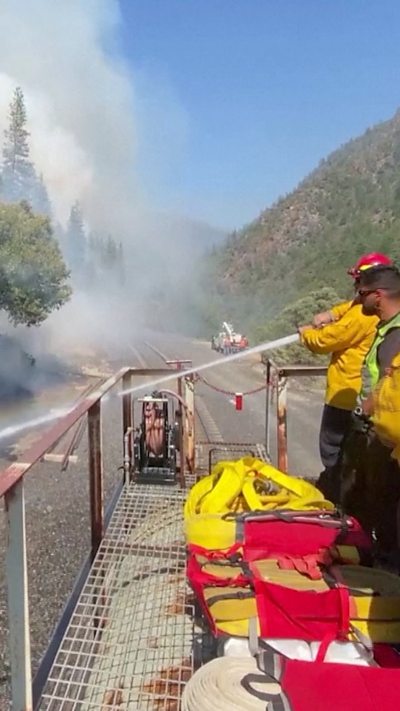 Firefighters spray water from roof of a train