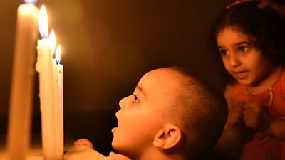 Boy stares at candle