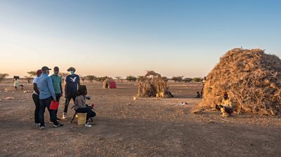 A Ͽ¼ Media Action crew films a man sitting in front of his thatched house in an arid landscape in northern Kenya