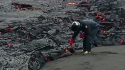 Scientist collecting lava sample