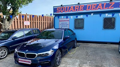 Car lot with electric car plugged in