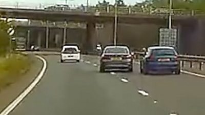 Footage includes a lorry overtaking on a single-carriageway, forcing a car off the road.