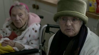 Two elderly women wrapped up in coats and hats