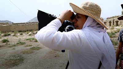Afghan filmmaker Roya Sadat looking through a camera