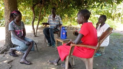 A family listening group in Tonj, South Sudan, gathers around to listen to Let's Talk About Us on a pre-loaded, solar-powered radio. Credit: BBC Media Action