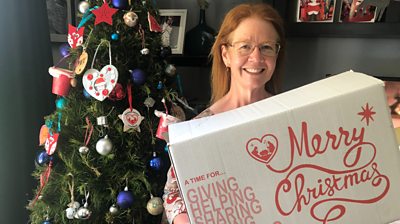 Woman holding reverse advent calendar box