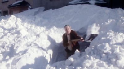 Man shovelling huge pile of snow