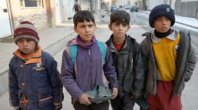 Four Afghan boys walk in the street in Kabul
