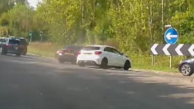 Two cars in a collision on the road