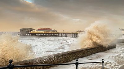 Waves crash over sea wall at Cromer in Norfolk