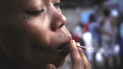 A woman smoking a drug called Kush in Sierra Leone