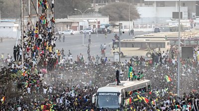 Fans celebrate as the bus drives along the road