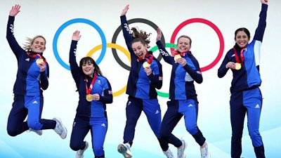 GB women's curling team jump with their gold medals