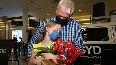 Grandfather and grandaughter embrace at Sydney Airport