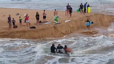 Surfers rescuing man from current