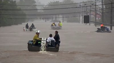 Boats perform resue in flooded street
