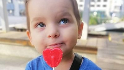 Polina holding a heart-shaped lollipop