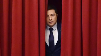 Volodomyr Zelensky stands behind a red curtain during filming in March 2019