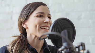 White women speaking into a radio mic