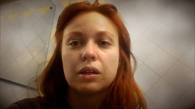 Ukrainian woman looks into camera as she records video diary