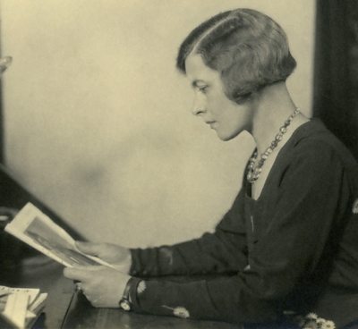 Hilda Matheson in side profile looking at a photograph