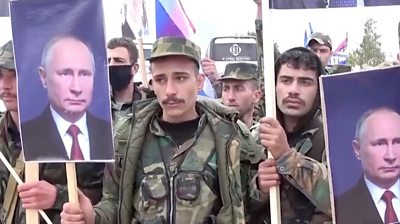 Syrian soldiers holding pictures of Vladimir Putin