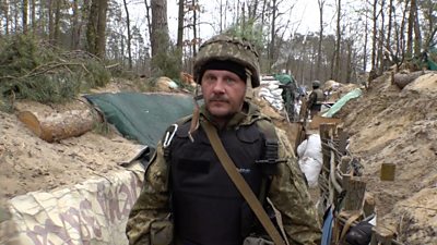Ukrainian soldier walks through trenches outside Kyiv