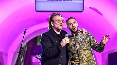 Bono singing with a Ukrainian soldier