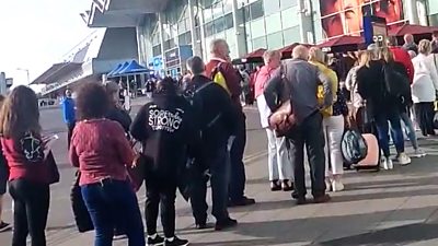 Travellers queuing outside airport