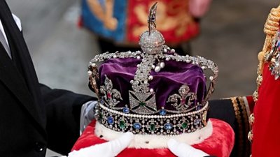 Crown being held by two people