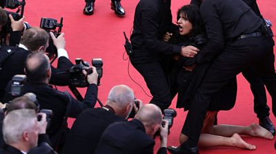 Protester on the Cannes red carpet