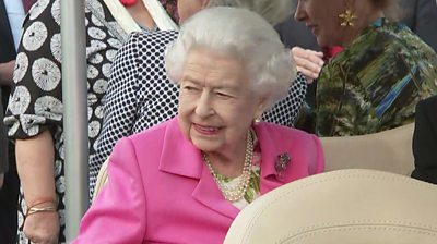 The Queen sitting in a golf buggy
