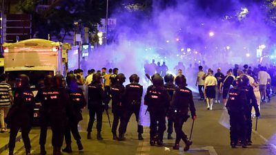 riot police facing football fans