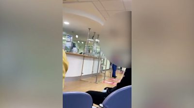 A nurse is filmed as she informs a packed accident and emergency waiting room of long delays.