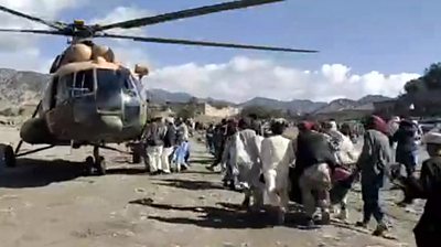 Injured people being carried to a helicopter