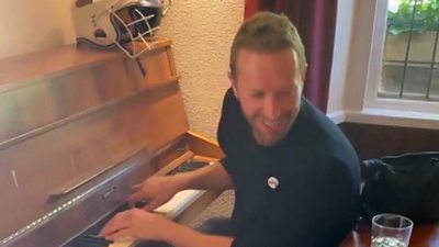Coldplay's Chris Martin plays a pub piano