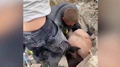 Man pulling another man from rubble