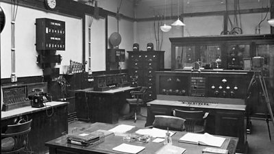 Savoy Hill 2LO control room with various bits of analogue equipment and a large desk