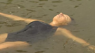 Woman floats on her back in a lake